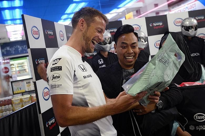 McLaren F1 driver Jenson Button giving Esso's social media competition winner Yasser Abdul Razak an exclusive gift pack yesterday.