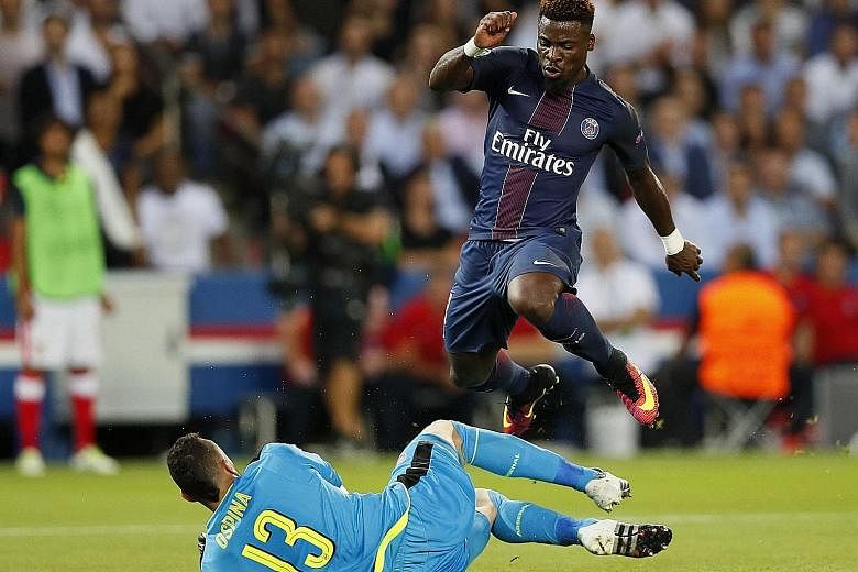Arsenal goalkeeper David Ospina vying for the ball with Paris Saint-Germain's Serge Aurier during the Champions League match on Tuesday. The Group A opener ended in a 1-1 draw.
