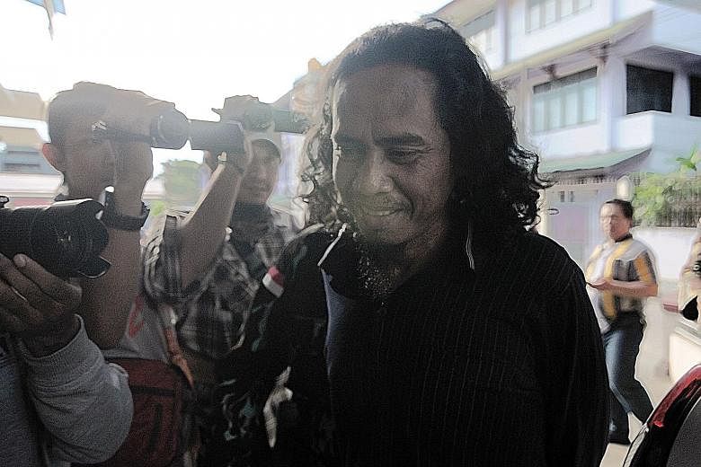 (Above) An Indonesian police spokesman giving details of the joint operation yesterday between the police and the military in which a member of the militant group, the Eastern Indonesia Mujahideen, was killed and its leader Basri (below) was captured