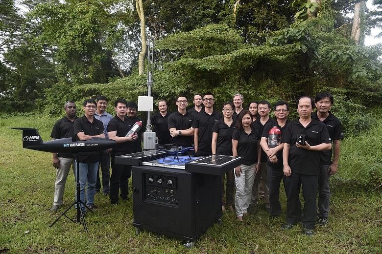 H3 Dynamics' Mr Wankewycz (sixth from left) and his team with their products. The Singapore firm makes unmanned aerial vehicles, portable power systems and drones.