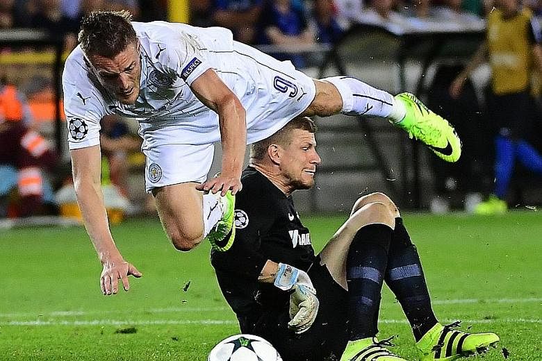 Leicester's Jamie Vardy falls after being tackled by Club Brugge goalkeeper Ludovic Butelle, resulting in a penalty. Riyad Mahrez netted for his second goal in the Champions League opener as the English champions ran out 3-0 winners.