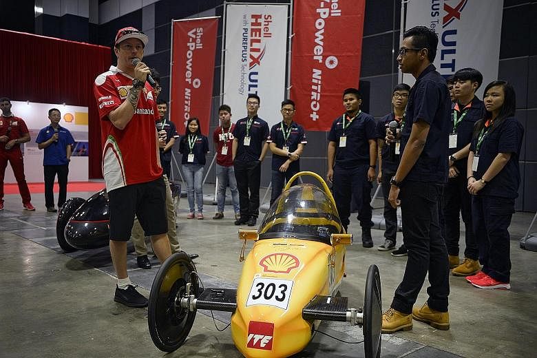 Ferrari's Kimi Raikkonen (left) speaks to Singaporean Muhammad Haikal Mohd Azminsham (right) and other participants of the Shell Eco-Marathon Asia at Suntec Convention and Exhibition Centre.