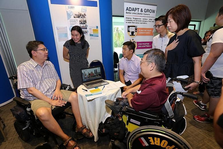 Minister for Social and Family Development Tan Chuan-Jin (seated, centre) and Ms Ku Geok Boon (right, in black), chief executive officer of SG Enable, at the training and job fair held at the Enabling Village yesterday.