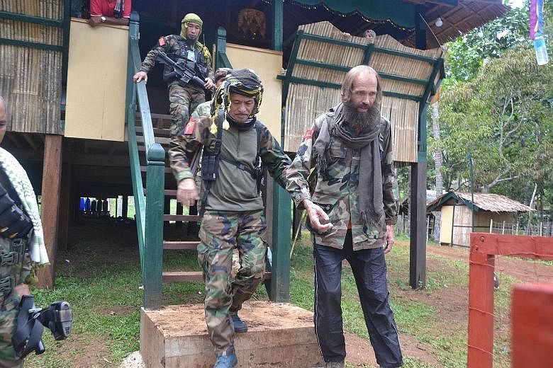 Rebel leader Nur Misuari (at left), whose group assisted in the hostage release, escorting Mr Sekkingstad in the town of Indanan on Jolo island yesterday. The Norwegian had been abducted by Abu Sayyaf militants in September last year.
