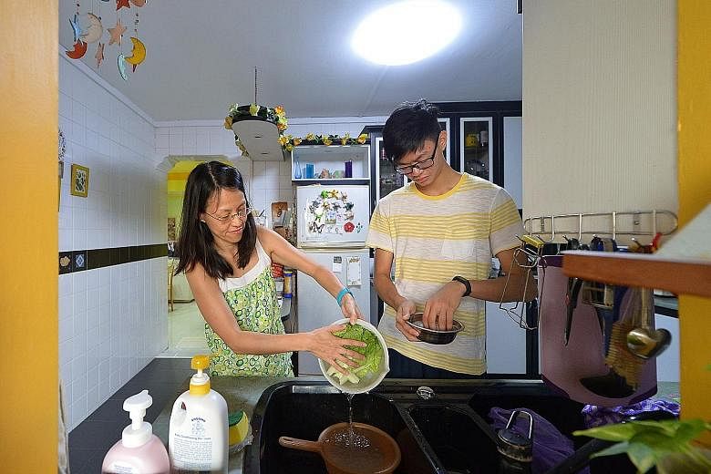 Student Timothy Chan, 16, and his mother Jackie, 46, washing vegetables and rice in their Tampines home. Over the years, there has been some progress in reducing water usage in Singapore homes.