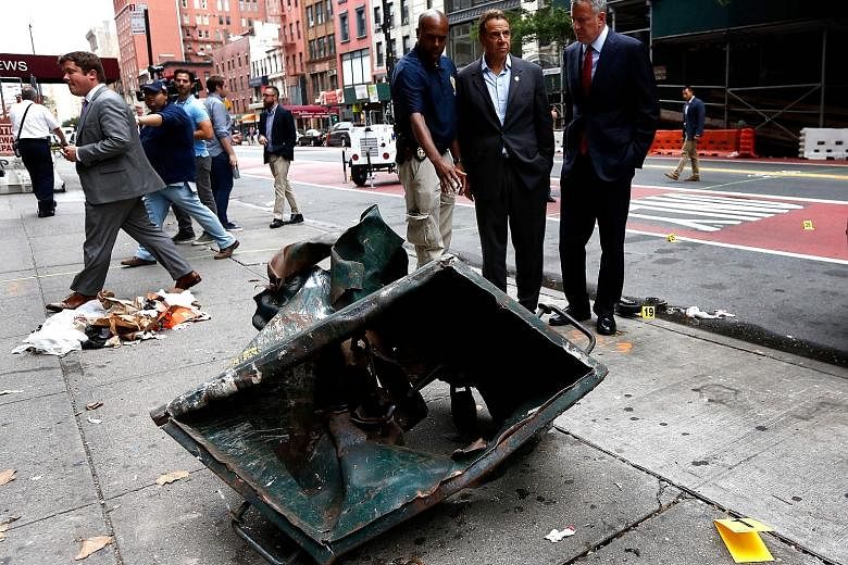(From right) New York Mayor Bill de Blasio and Governor Andrew Cuomo on Sunday visiting New York City's Chelsea neighbourhood, where they were shown a dumpster mangled by the force of last Saturday's explosion.