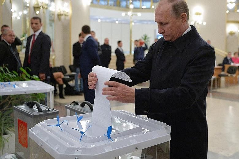 Russian President Vladimir Putin casting his vote at a polling station in Moscow on Sunday. With 93 per cent of votes counted and his United Russia party a clear winner, the Communist Party is on track to come second with 42 seats, the populist LDPR 