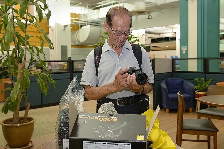 Mr Lui admiring his brand-new Nikon yesterday. The 79-year-old, an award-winning photographer, could not afford the $700 needed to repair his existing camera, so an effort was made to get him a new one.
