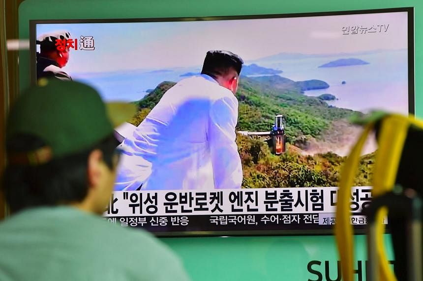 A TV news report showing North Korean leader Kim Jong Un looking at the country's latest ground test of a rocket engine yesterday. 