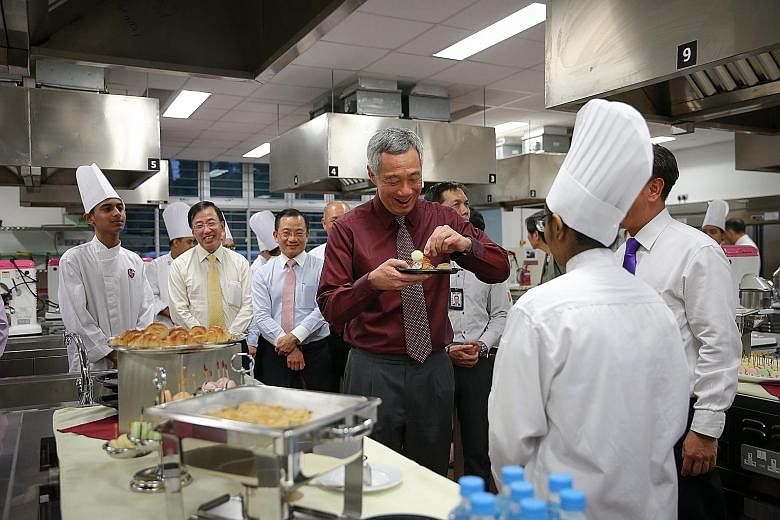 PM Lee sampling pastries made by NorthLight students yesterday. The school has changed not just the lives of its students, but has also influenced Singapore's wider education system, he said.