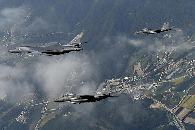 A US B-1B Lancer bomber, flanked by two South Korean F-15K fighters, flying over Osan Air Base, south of Seoul, in a handout photo released by the South Korean Air Force yesterday. The flight came a day after Pyongyang claimed it had successfully tes