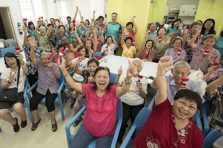 Participants from the Awwa Senior Activity Centre holding up the Samsui women dolls they made with staff volunteers from SGX last month.