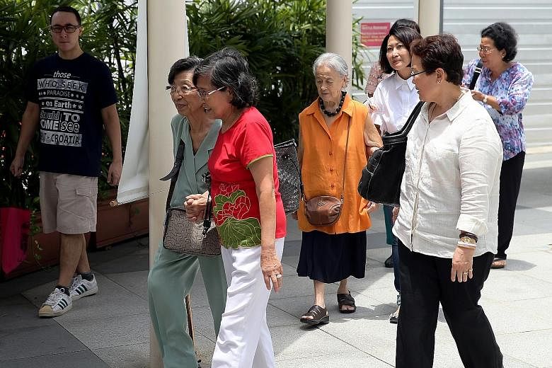 Madam Chung Khin Chun (in orange top) leaving the State Courts with her relative and friends after a hearing earlier this month.