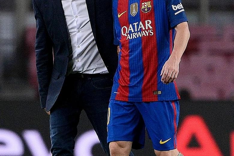 Barcelona's Lionel Messi (right) with the team's doctor after being injured during the match against Atletico Madrid.
