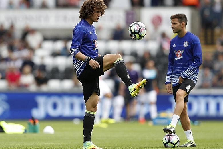 Chelsea's David Luiz (far left) will likely retain his place in central defence against Arsenal today, while team-mate Cesc Fabregas will be hoping that he is in the starting line-up after scoring a brace against Leicester City in the League Cup on T