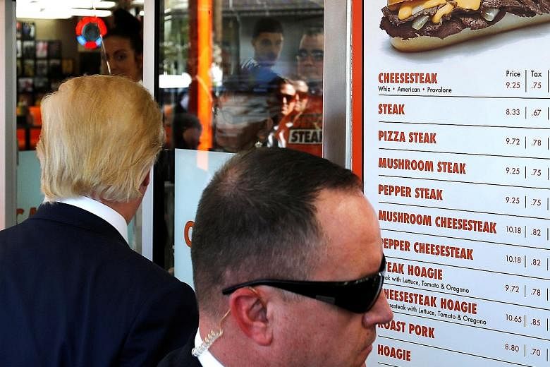 A Secret Service agent keeping watch as Mr Trump made a stop at a restaurant in Philadelphia on Thursday.
