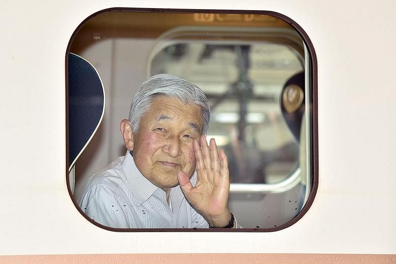 Emperor Akihito waves from a bullet train before departing Tokyo on Aug 20 for a visit to Nagano and Gunma prefectures. The Emperor has hinted that he wishes to step down.