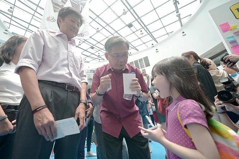 Mr Ng (at left) and Mr Gan having a conversation with five-year-old Kayleigh Lim about eating right. The two ministers are co-chairs of the the 16-member Diabetes Prevention and Care Taskforce.