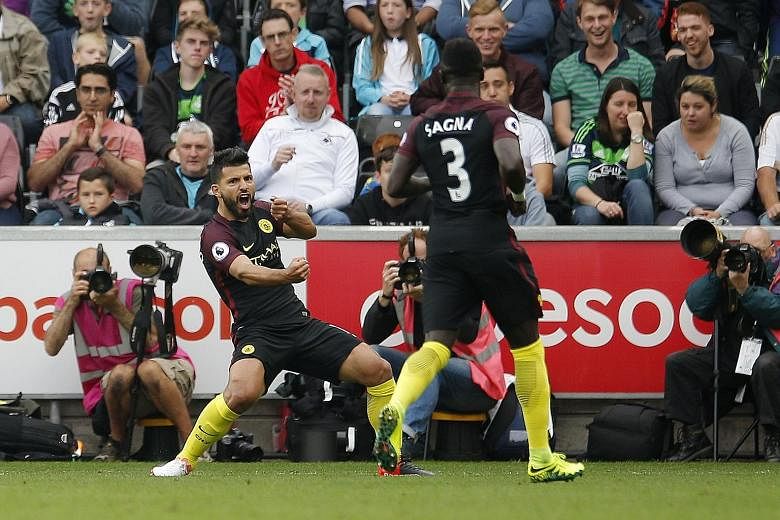 Manchester City's Sergio Aguero celebrating with Bacary Sagna after the first of his two goals against Swansea yesterday. He returned to domestic duties after a three-match suspension and took just nine minutes to open the scoring in the 3-1 win over