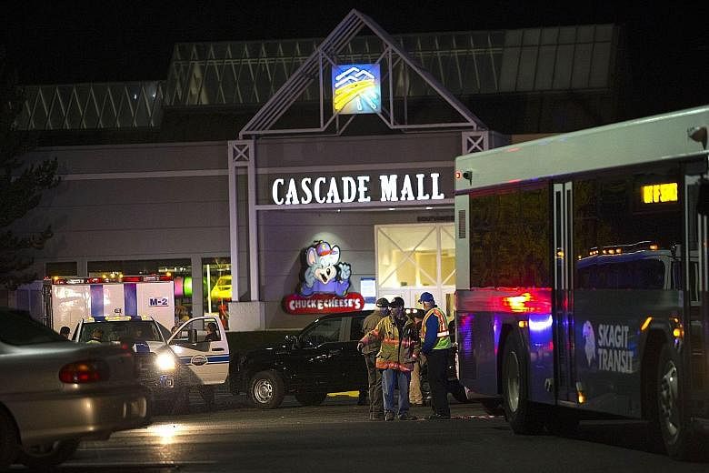Police at the Cascade Mall (left) in Washington state after Friday night's shootings by a man (above, captured on surveillance video) armed with a rifle.