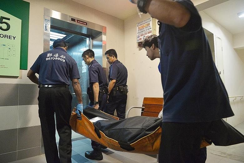 The body of the 61-year-old man, who was reportedly beaten to death, being taken away at Block 152B, Bishan Street 11 early yesterday morning. The 25-year-old man who was arrested in connection to the death is believed to be the younger of the victim