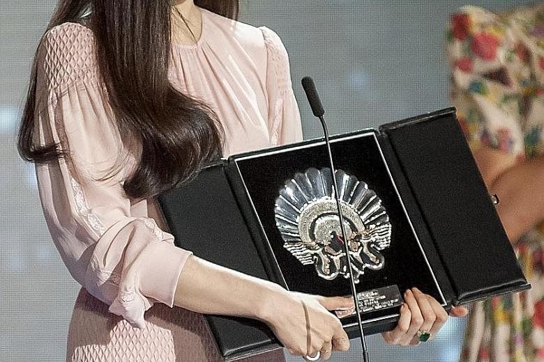 Fan Bingbing (above) with the Best Actress award for I Am Not Madame Bovary and Spain's Eduard Fernandez took home the Best Actor Silver Shell for Smoke And Mirrors.