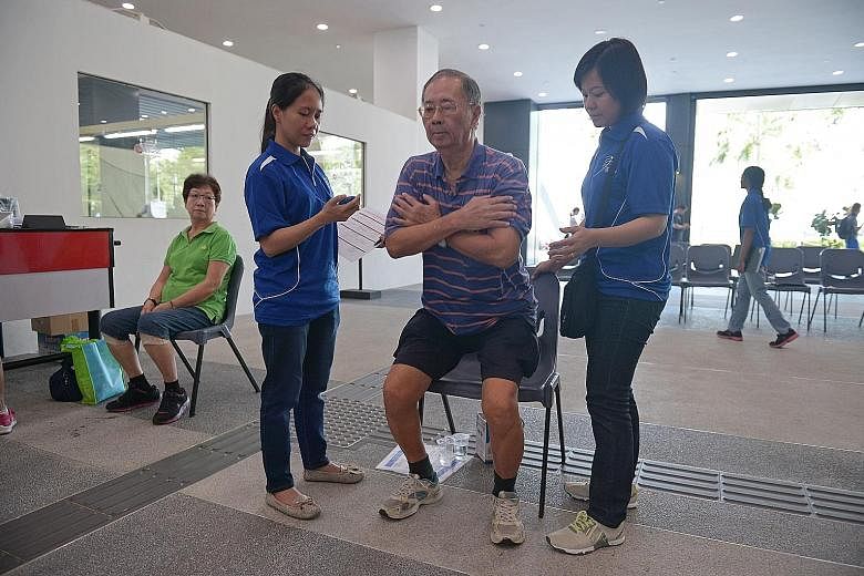 Mr Lim taking the fitness test yesterday at Pasir Ris Sports Complex while his wife, Madam Tan Sai Choo (left), looks on.