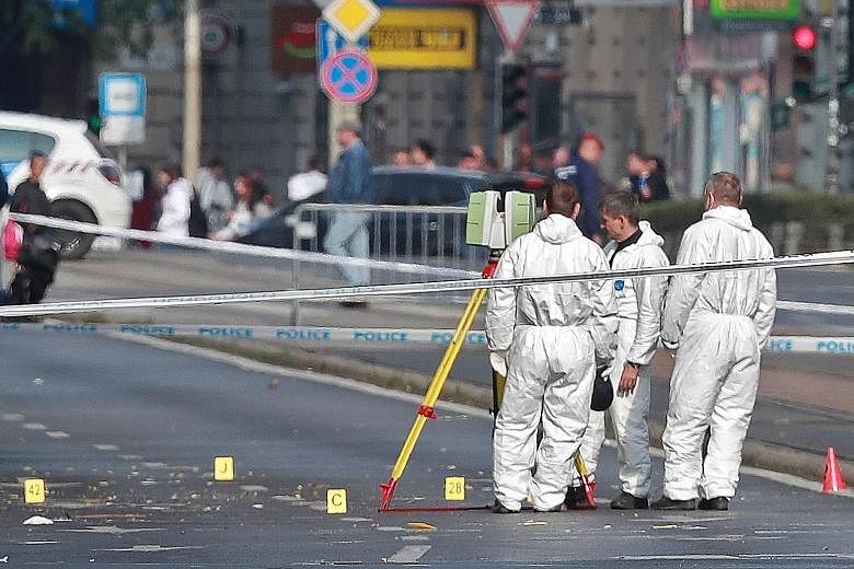 Hungarian police officials at the scene of an explosion of unknown origin in Budapest on Saturday. A government spokesman would not say if the blast was a deliberate attack.