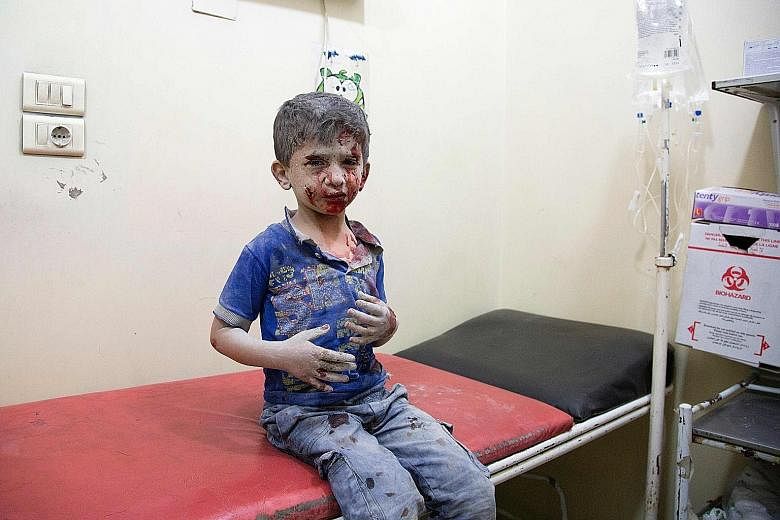 An injured Syrian boy awaiting treatment at a makeshift hospital on Saturday following air strikes on rebel-held areas of Aleppo. Government air strikes on areas of Aleppo have reduced neighbourhoods such as Tariq a-Bab (above) to rubble and flooded 