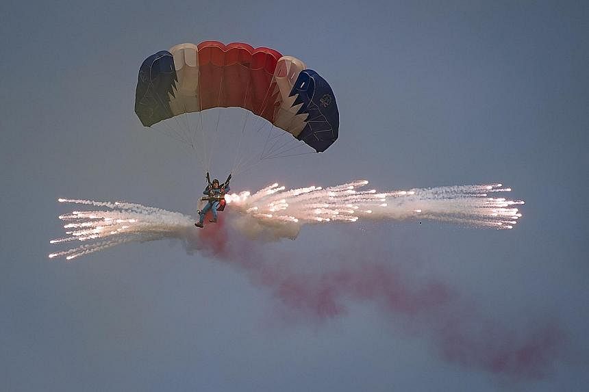A parachutist releasing fireworks for an aerial display during the second day of the Wonsan Friendship Air Festival yesterday. Just weeks after carrying out its fifth nuclear test, North Korea put on an unprecedented civilian and military air force d