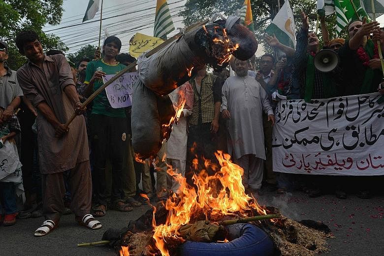 Pakistani demonstrators in Lahore burning effigies of Indian Prime Minister Narendra Modi and External Affairs Minister Sushma Swaraj during a protest to show solidarity with those living in Indian- administered Kashmir on Sunday. The Indus Water Tre