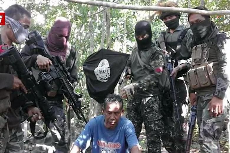 The five kidnapped Malaysians (left and below), surrounded by their Abu Sayyaf captors. They were captured on July 18 off eastern Sabah. A ransom of 100 million pesos (S$2.8 million) has been demanded.