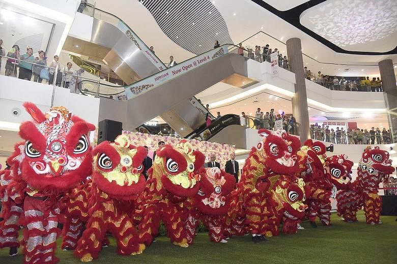 Above: A lion dance performance helped to mark the official opening of Compass One, previously called Compass Point, yesterday. Left: The new rooftop playground.