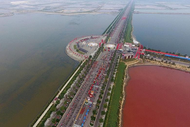 The colour of an ancient salt lake in the Chinese city of Yuncheng in Shanxi province has turned to rose pink on one side because of the spread of red-coloured algae called dunaliella salina. Many residents flocked to the area this week to see the ch