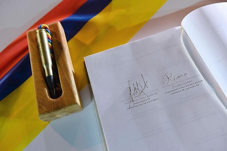 The peace deal with the signatures of Mr Santos (at right) and Timochenko, and the "bullet pen" used to sign it.
