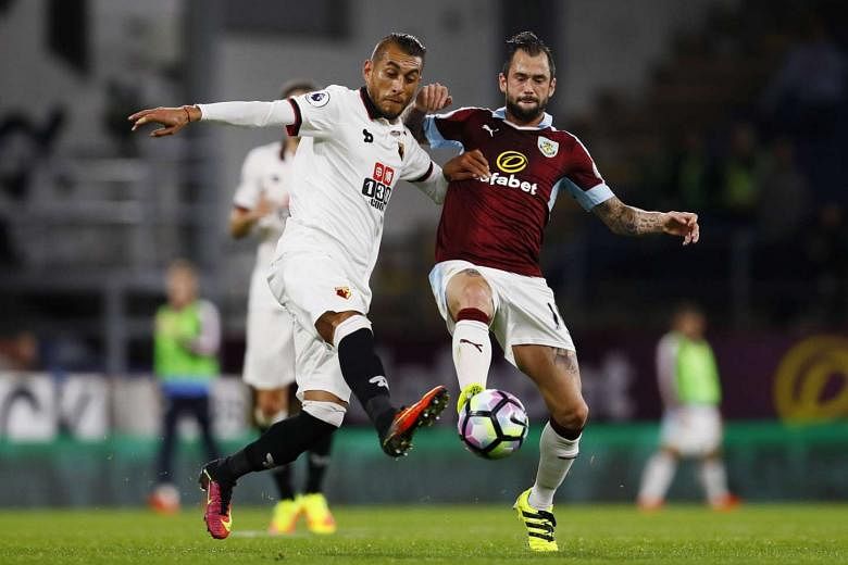 Watford midfielder Roberto Pereyra (left) challenging Burnley's Steven Defour for the ball during a Premier League match on Monday. Belgium international Defour led his side to a 2-0 victory with two assists.