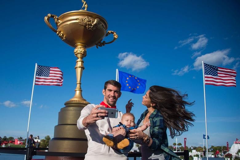 Above: Michael Phelps and his fiancee Nicole Johnson take a selfie with their son Boomer at Hazeltine. Phelps, a 23-time Olympic swimming champion, was yesterday set to take part in the Ryder Cup Celebrity Scramble 2016.