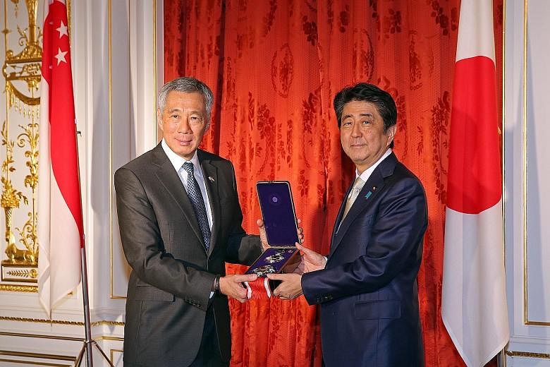 PM Lee receiving the Grand Cordon of the Order of Paulownia Flowers, on behalf of the late Mr Lee Kuan Yew, from Mr Abe in Tokyo yesterday.