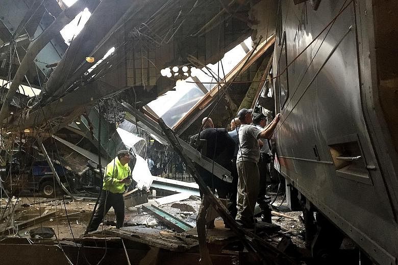 Train personnel inspecting a New Jersey Transit train that crashed into the platform at the Hoboken Terminal yesterday during morning rush hour, killing at least three people and injuring more than 100 others. A witness said the train hit a cement bl