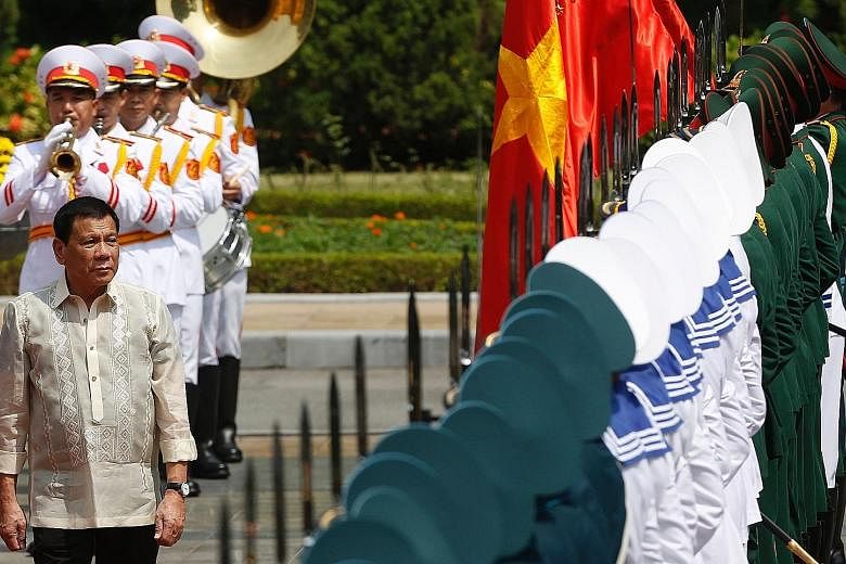 Philippine President Rodrigo Duterte reviewing a guard of honour during a welcoming ceremony at the Presidential Palace in Hanoi yesterday. His aides told reporters that he and Vietnamese President Tran Dai Quang discussed the South China Sea dispute