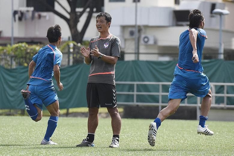 Albirex Niigata coach Naoki Naruo (centre) conducting training at the Jurong East Stadium. His eye for detail has been cited as a reason why Albirex are on the brink of completing an unprecedented treble this season.