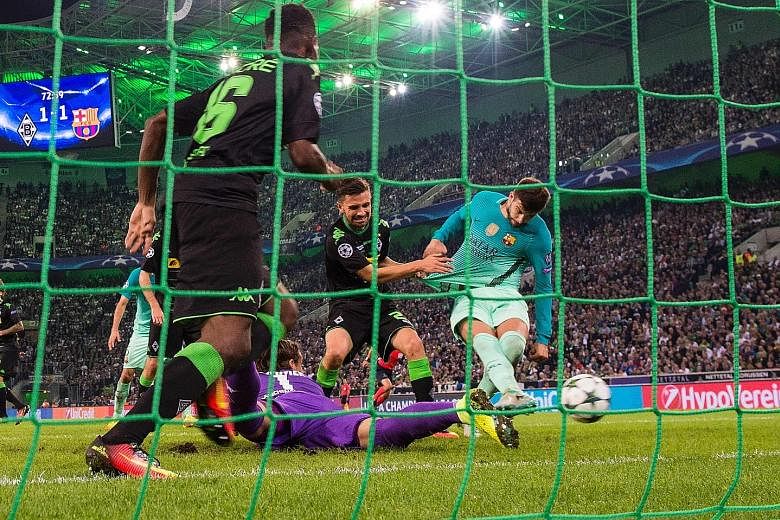Barcelona defender Gerard Pique (right) scores the winner from close range after Monchengladbach goalkeeper Yann Sommer (in purple) fails to clear the ball to safety following a shot by Luis Suarez.