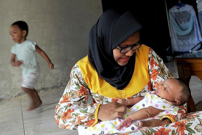 Ms Yenni Linda Yanti with her newborn baby at a government hospital in Aceh. The nurse is the first person to benefit from the new policy. She says she is happy as she now has more time to spend with her child.