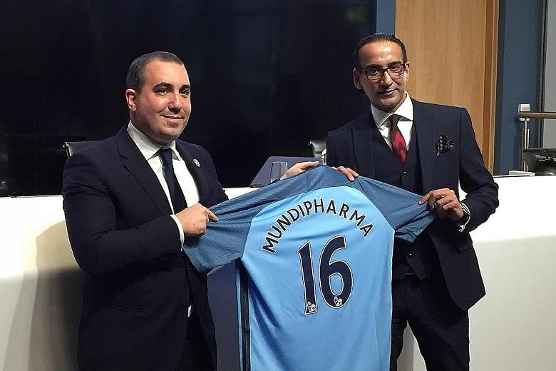 Manchester City chief operating officer Omar Berrada gives a commemorative jersey to Mundipharma's president for Asia-Pacific, Latin America, the Middle East and Africa Raman Singh (right). City and Mundipharma inked a three-year partnership on Thurs