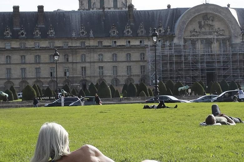 Sunbathers taking advantage of the fine weather in Paris this week. The planet has already heated up 1 deg C above the pre-industrial benchmark, scientists reported last week.
