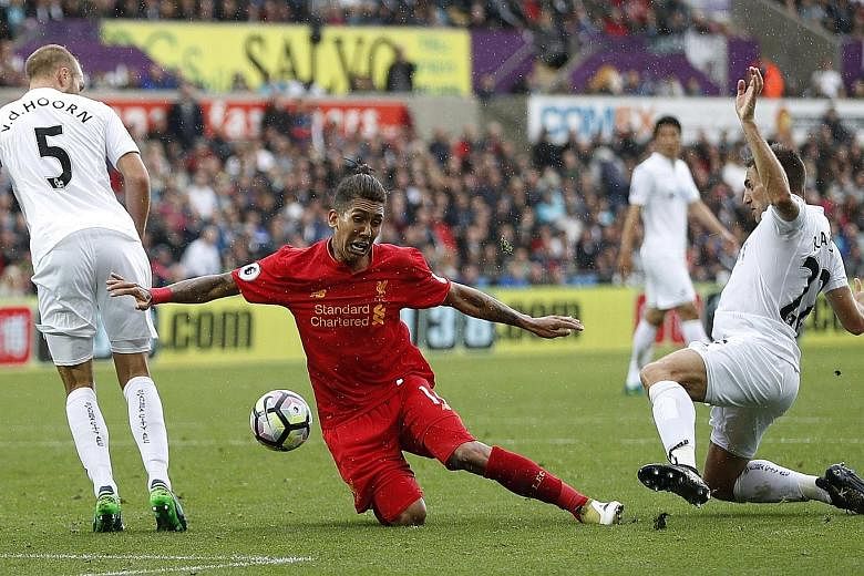 Liverpool's Roberto Firmino is fouled by Swansea's Angel Rangel, resulting in a penalty which James Milner tucked away late on. The Brazilian had headed the Reds level earlier, as they recovered from a horrid first half.