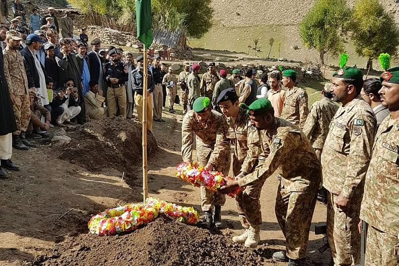 In this photo released on Friday, Pakistani troops lay a wreath at the grave of a soldier killed in firing along the Line of Control that divides the disputed territory of Kashmir between India and Pakistan.
