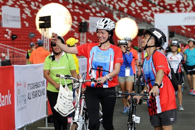 It's wefie time as two participants pose proudly after finishing The Straits Times Ride at yesterday's OCBC Cycle. Nearly 7,000 riders took to the streets of downtown Singapore in the nation's largest mass cycling event to take part in the 42km The S