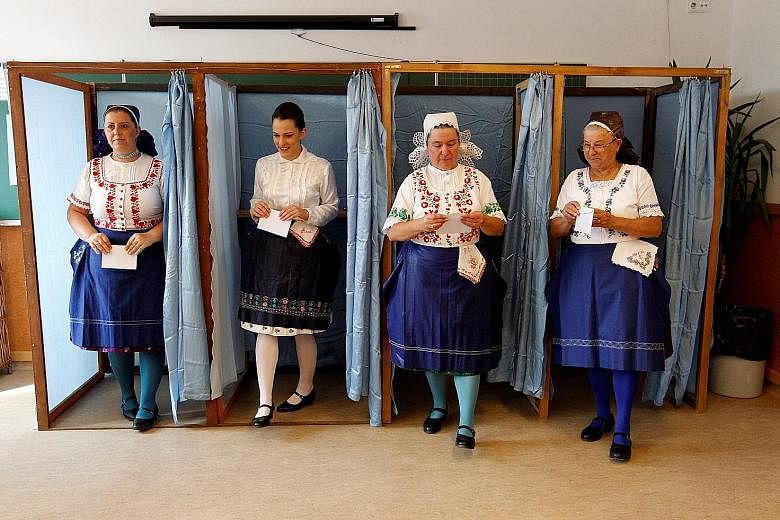 Hungarian women in traditional attire at Sunday's referendum on EU migrant quotas. Just 40 per cent of about 8.26 million eligible people cast a valid vote, less than the 50 per cent needed to legitimise the result.