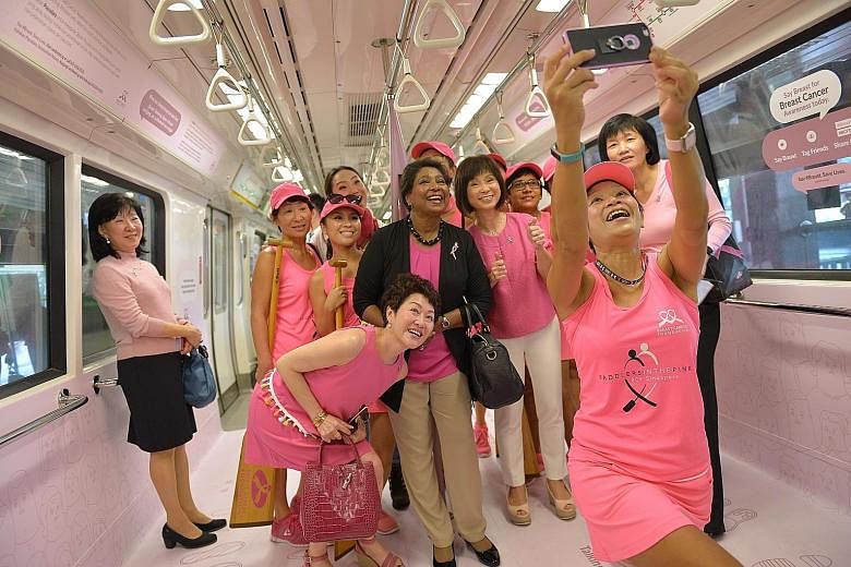 Senior Minister of State for Health Amy Khor (fourth from right), and BCF president Noor Quek (in black jacket) at the launch of the "pink" train yesterday. The train features statistics about breast cancer and will also include social "nudges" to en